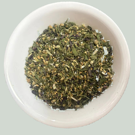 A white ceramic bowl filled with organic dried loose herbal tea blend, yarrow, peppermint, peppermint 